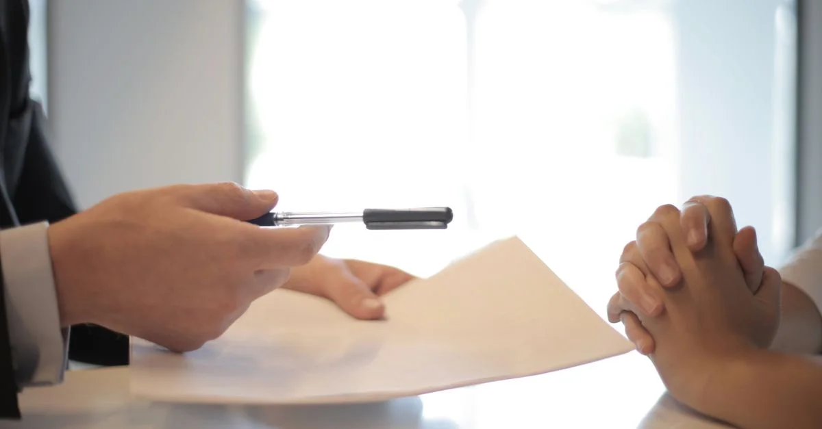 Gros plan sur une signature de contrat avec des mains sur des documents. Interaction professionnelle.