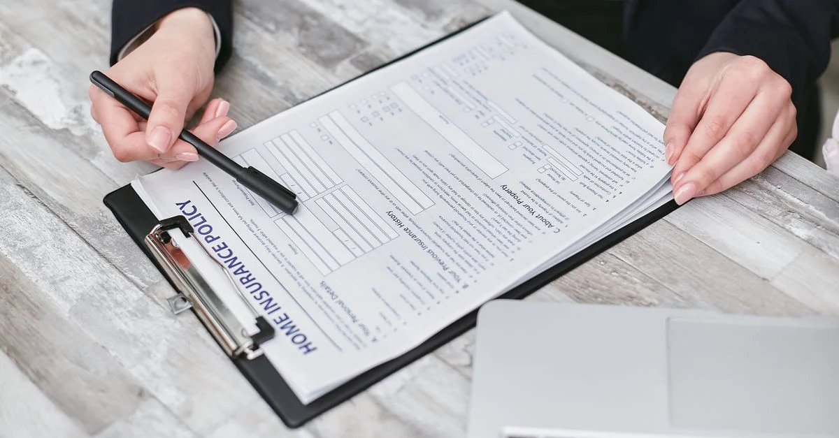 Gros plan sur des mains examinant une police d'assurance habitation, mettant en avant le professionnalisme et la finance.